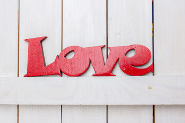 Love word made from red wood on white background. St Valentine's or Mothers Day greeting card. Wedding invitation