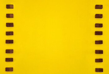 茶色いウッドキューブが縦に2つずつ並ぶ黄色い装飾フレーム