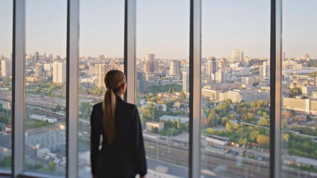 Businesswoman enjoying city view in office. Pensive concerned manager looking