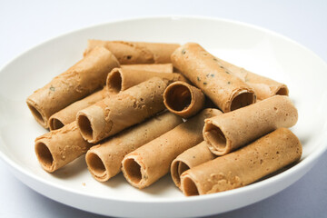 Crispy egg roll or crispy golden curl placed in a white plate, white background. Isolated.