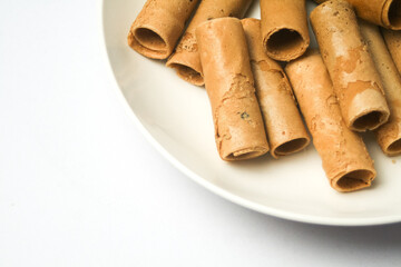 Crispy egg roll or crispy golden curl placed in a white plate, white background. Isolated.