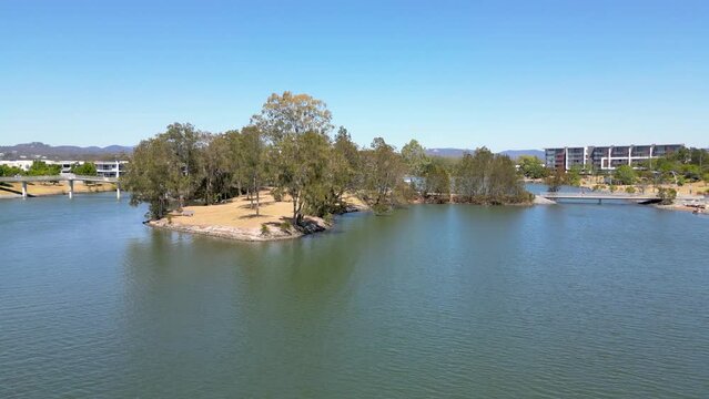 Drone flying westward across Lake Orr at Varsity Lakes in Queensland, Australia with the hinterland in the background.