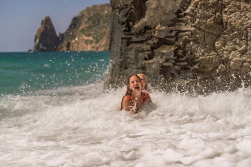 Fototapeta premium Women ocean play. Seaside, beach daytime, enjoying beach fun. Two women in red swimsuits enjoying themselves in the ocean waves.