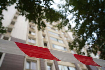 Fencing tape in front of a high-rise apartment building.