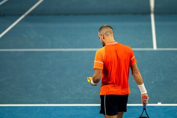 Professional athlete playing tennis on a sports court in europe.