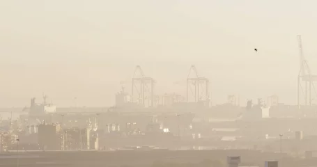 Foto auf Acrylglas Tor A hazy view of a port with cranes and ships, with copy space