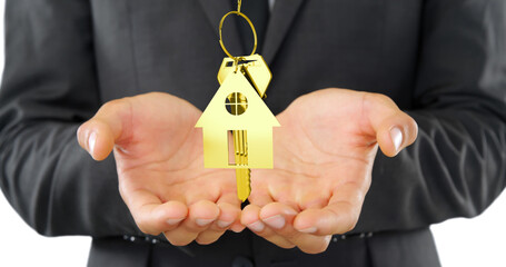 A businessman presents a golden house key, symbolizing real estate investment