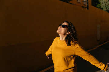 Positive woman in sunglasses on street