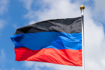 Flags of Russia, Donetsk People's Republic. The Donetsk and People's Republics are partially recognized state entities in Eastern Europe. Flag against the blue sky. Great for news.