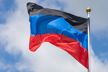 Flags of Russia, Donetsk People's Republic. The Donetsk and People's Republics are partially recognized state entities in Eastern Europe. Flag against the blue sky. Great for news.