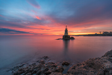 Solitude Radiance: Lone Lighthouse at Sunrise