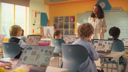 Elementary School Children Learning Basic Computer Knowledge: Teacher Educating Smart Diverse Kids in a Modern Colorful Classroom. Schoolchildren Getting Experience with Technology