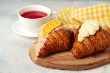 Fresh croissants with cup of tea on table