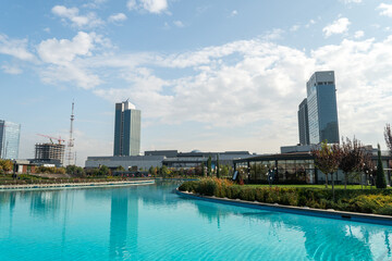 Awesome view of contemporary buildings reflected in pool of Tashkent City Park in Tashkent,...
