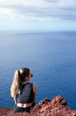 Serene Majesty, A Woman Surrenders to Natures Harmonious Embrace on a Crimson Coastal Throne