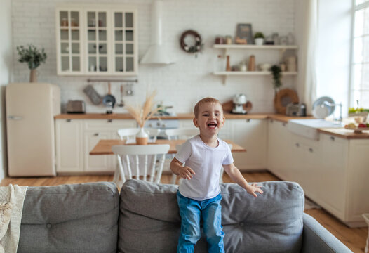 Little Boy Jumping On The Couch And Having Fun