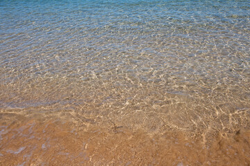 Beach background. Calm beautiful ocean wave on sandy beach. Sea view from tropical sea beach.