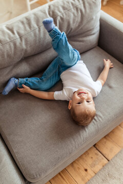 Little Boy Jumping On The Couch And Having Fun