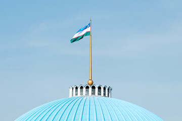 Waving Flag of Uzbekistan in Blue Sky. Uzbekistan Flag on pole for Independence day. symbol of the...