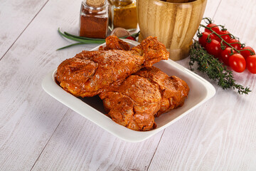 Raw turkey shoulder wing in Indian tandoori marinade