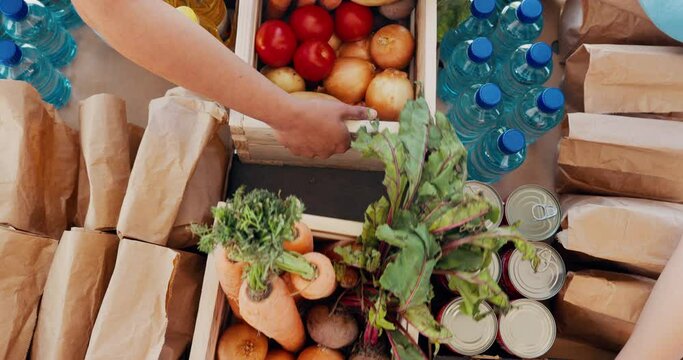 Volunteer, hands and box with food for donation, charity and community service with groceries and support. Helping, solidarity and humanitarian aid with assistance, unity and giving with aerial view