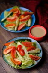 garden salad. romaine lettuce, shaved carrots, sliced tomato, cucumber with peanut sauce. appetizer. 