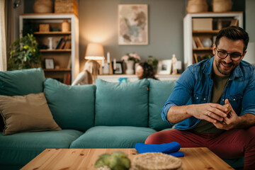 Man sitting on the couch, cleaning a table in the living room. copy space