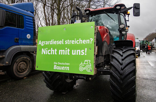 Bauerndemo in Berlin - Traktor mit bedruckten Protestschildern.
