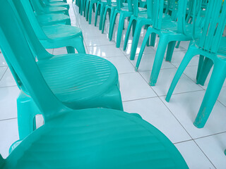 Green plastic chairs are lined up on white ceramics. backrest chair. event