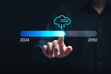 Reduce CO2 emissions. Businessman touch on virtual status bar of 2024 to 2050 with carbon reduction...