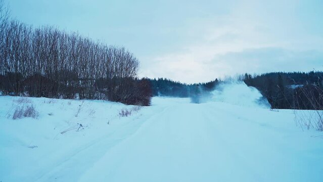 Man Clearing Snow Off The Field With Snow Blower During Winter In Indre Fosen, Norway. wide shot