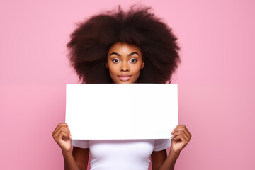 An African girl holding a blank placard on a pink background