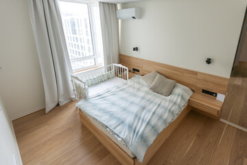 Interior photo large bedroom with large bed and small cot family bedroom.