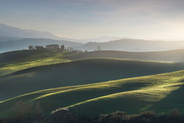 Landscape in Tuscany with farmhouse and rolling hills on a winter afternoon