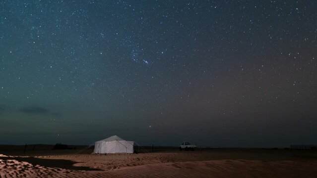 Time lapse of night Stars motion with Gemini Meteors shooting in safari desert camping camel farm Bedouin