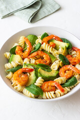 Pasta salad with shrimps, avocado and spinach. Healthy eating. Seafood.