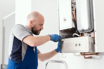 Professional engineer servicing a boiler at home