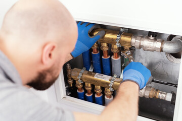 Professional plumber installing plumbing manifolds - obrazy, fototapety, plakaty
