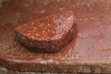 A stone mortar or pestle or silbatta/sil batta used for making chutney, wet, closeup