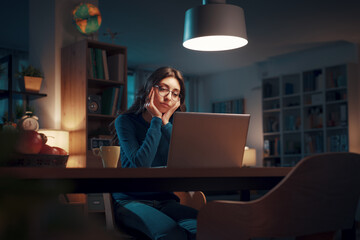 Young woman working with her laptop at night