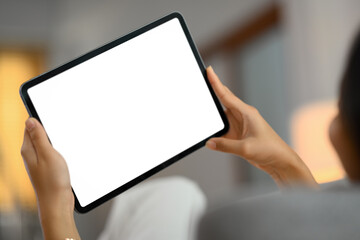 Closeup woman using digital tablet while lying on couch at home