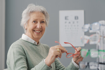 Happy senior woman trying new prescription glasses