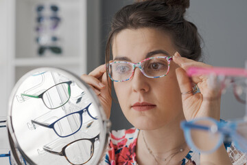 Young woman choosing her new glasses