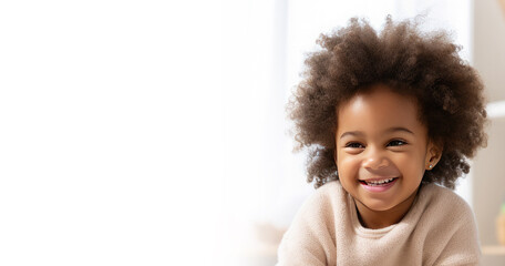 Portrait of a happy cute African American kid with afro fluffy hair looking at the camera. Black beautiful happy smiling healthy child. Banner. Copy space for text