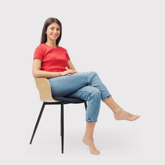 Portrait of a young woman sitting on a chair - obrazy, fototapety, plakaty