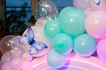 Photo zone made of pink and blue inflatable balloons, decorated with butterflies.