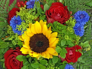 Sunflower, alchemilla, centaurea cyanusand and red roses in bouquet. Summer flowers.  - 713019737