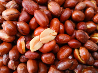 Fried peanuts on wooden plate on gray background. Deep fried peanuts on plate. Food background. Close up
