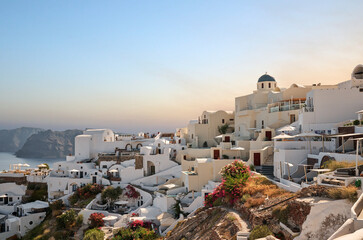 Panoramic view of traditional white architecture with windmills, greek village of Oia village,...