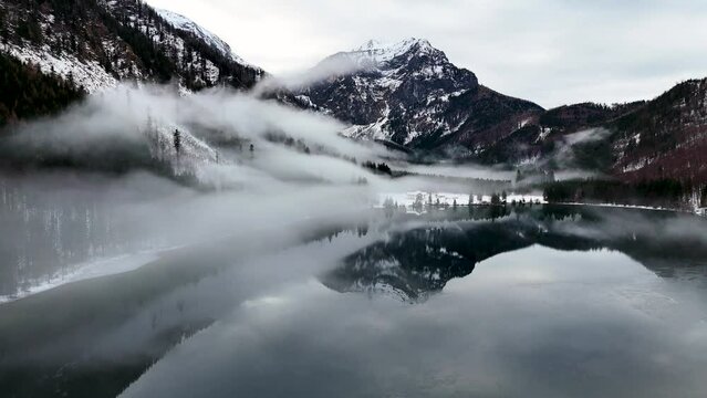 Drohnenflug &uuml;ber dem See in den Bergen in sch&ouml;ner Landschaft im Winter im Salzkammergut